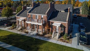 A two-story brick house with a front porch, a garage, and a driveway. - Location, location!  Spacious 4-BR double apartment near Cottonwood Canyons (Cottonwood Heights)
