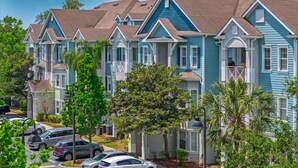 A row of townhouses with a uniform architectural style, featuring gabled roofs and a central entrance. - 2 Ensuites Close to Disney Intertational Epic (kissimmee)
