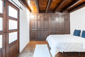 Un dormitorio con una cama grande, un armario de madera y una ventana.