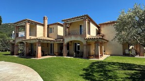 A two-story house with a patio and a well-maintained lawn.