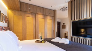A hotel room with a bed, a bedside table with a bottle and grapes, a TV, and a wardrobe. - Próximo a Paulista com piscina  (Sao Paulo)