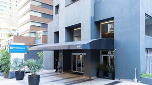 A modern building with a blue facade, a sign reading "WYNDHAM São Paulo Paulista," and a number "540" above the entrance. - Próximo a Paulista com piscina  (Sao Paulo)