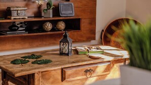 A wooden desk with a lantern, books, and decorative items. - 3 Quartos com vaga no Prado (Belo Horizonte)