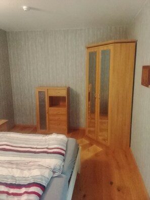 Une chambre à coucher avec un lit, une armoire et un petit bureau.