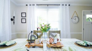 A dining table set with plates, napkins, and a centerpiece. - Premier Homestead Retreat on 1.5 Acres: Pets, Spa, Firepit, Chickens, King, Gym (Wake Forest)