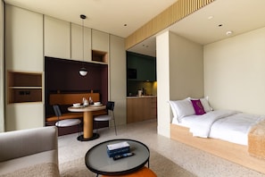 A modern hotel room with a bed, a dining area, and a kitchenette. - Deluxe Studio with Balcony Full Burj Khalifa View (Dubai)