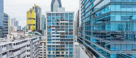 A high-rise building with a modern glass facade, surrounded by other tall buildings in an urban setting.