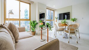 Una sala de estar moderna con un sofá, una mesa de comedor, sillas y plantas en macetas.