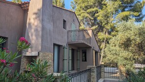 Una casa moderna con facciata in pietra, un balcone e una scalinata in pietra che conduce all'ingresso.