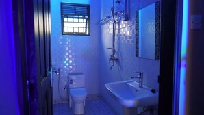 A small bathroom with a toilet, sink, and shower. - Kamfart Safari Lodge (Jinja)