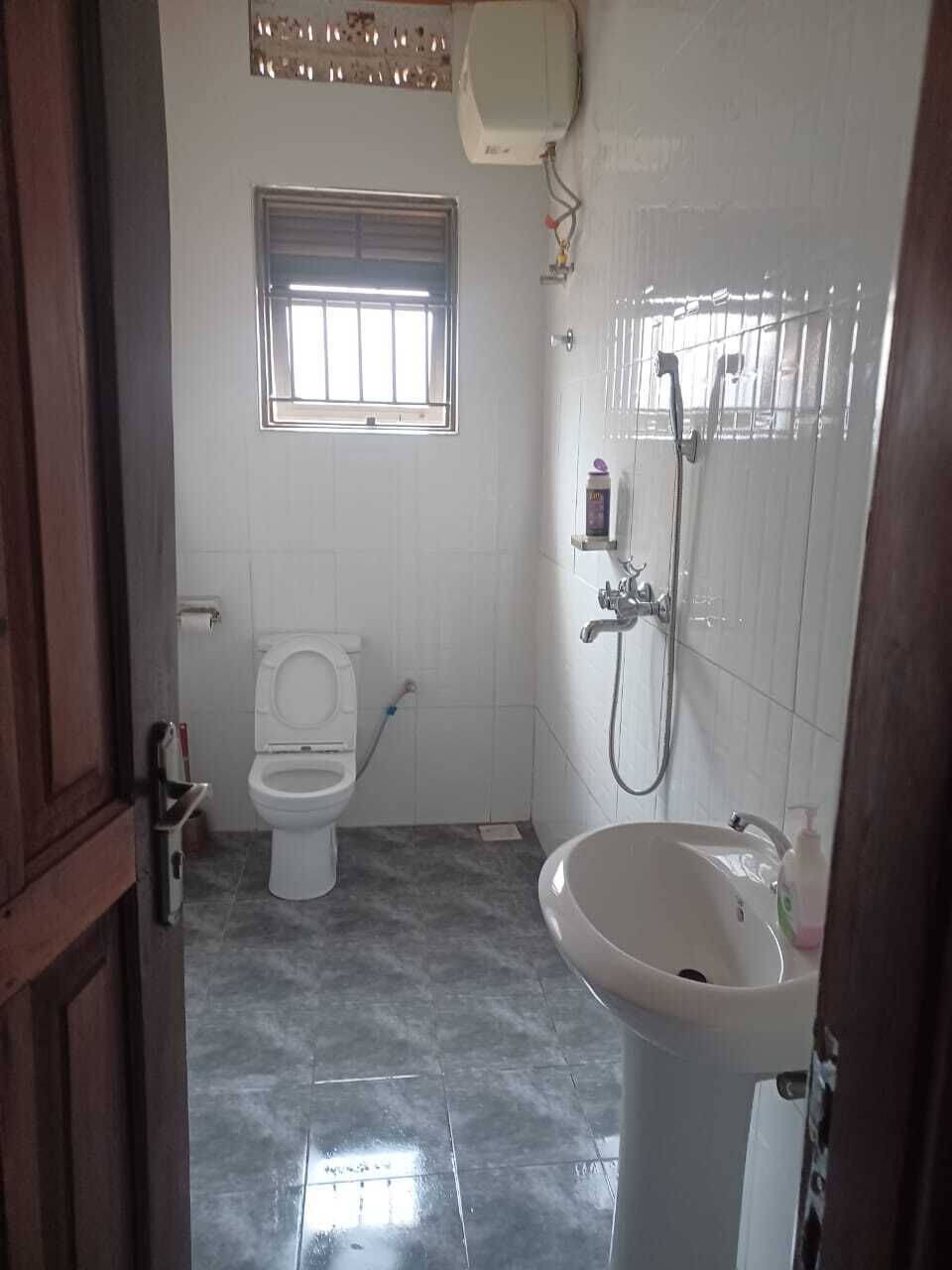 Un baño con inodoro, lavamanos, ducha y ventana.