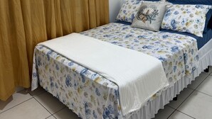 Un dormitorio con cama, cortinas y aire acondicionado.