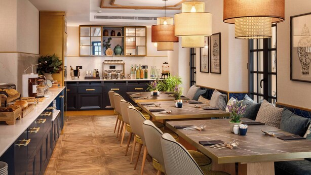 Une cuisine moderne dotée d’un îlot central, d’un coin repas avec des chaises et d’un comptoir-bar.