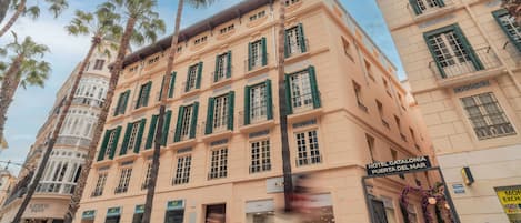 A multi-story hotel with a classic architectural style, featuring balconies and a prominent entrance.