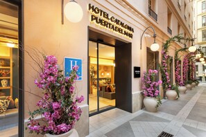 Hotellin sisäänkäynti, jonka yläpuolella on kyltti, jossa lukee: ”HOTEL CATALONA PUERTA DEL MAR”.