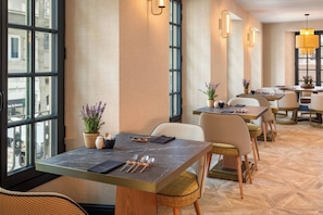 A restaurant interior with tables, chairs, and potted plants. - Catalonia Puerta Del Mar (Málaga)