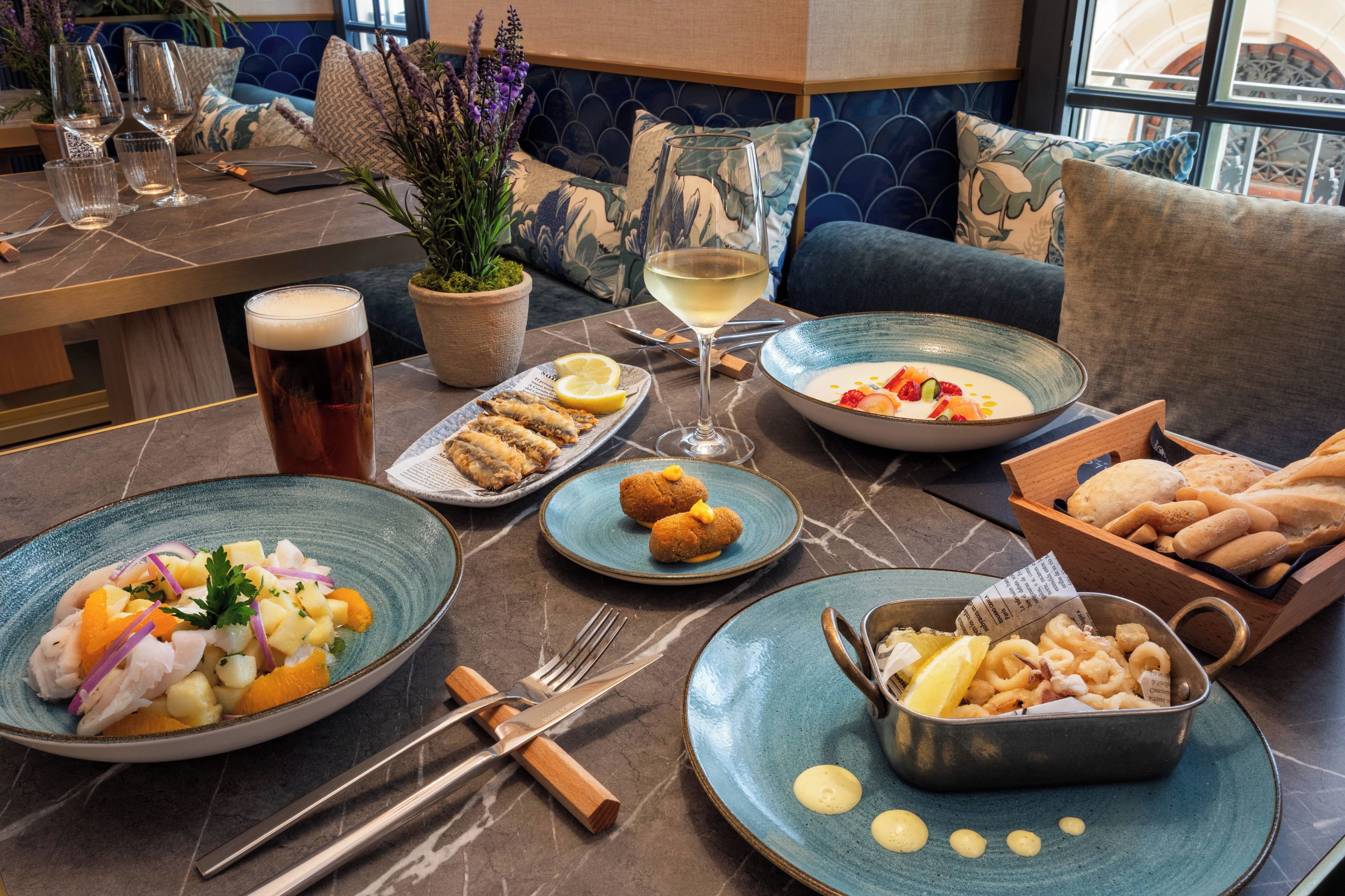 Une table à manger avec différents plats, des verres et des couverts.