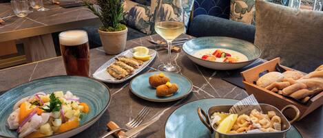 A dining table with various dishes, glasses, and cutlery.