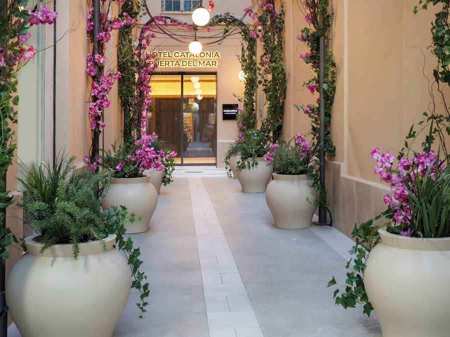 A hotel entrance with a sign reading 'HOTEL CATALONIA PUERTA DEL MAR'.