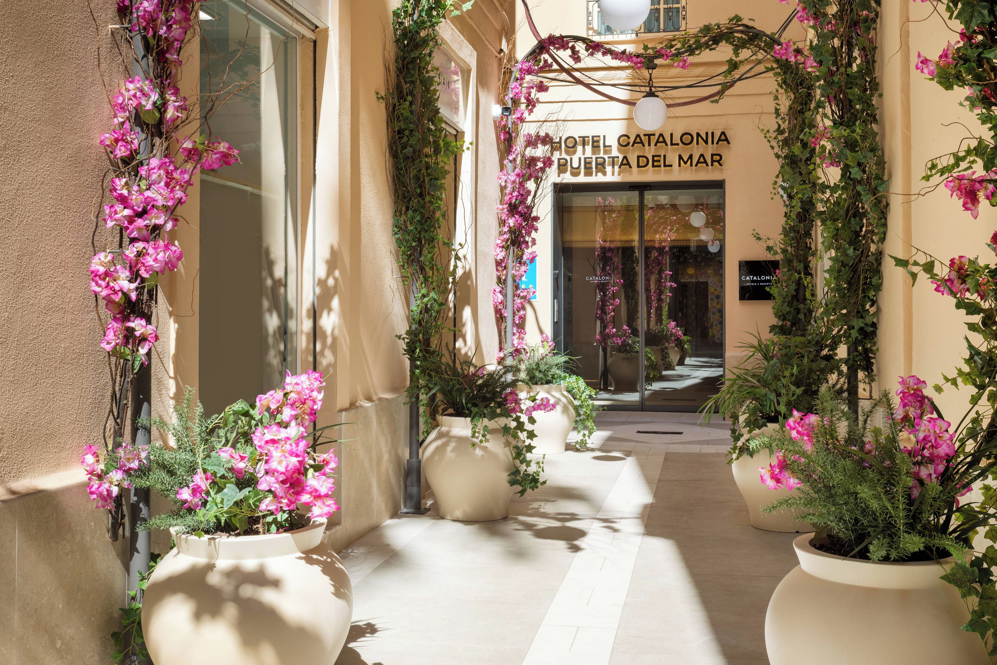 Entrada de um hotel com uma placa indicando 'HOTEL CATALONIA PUERTA DEL MAR'.