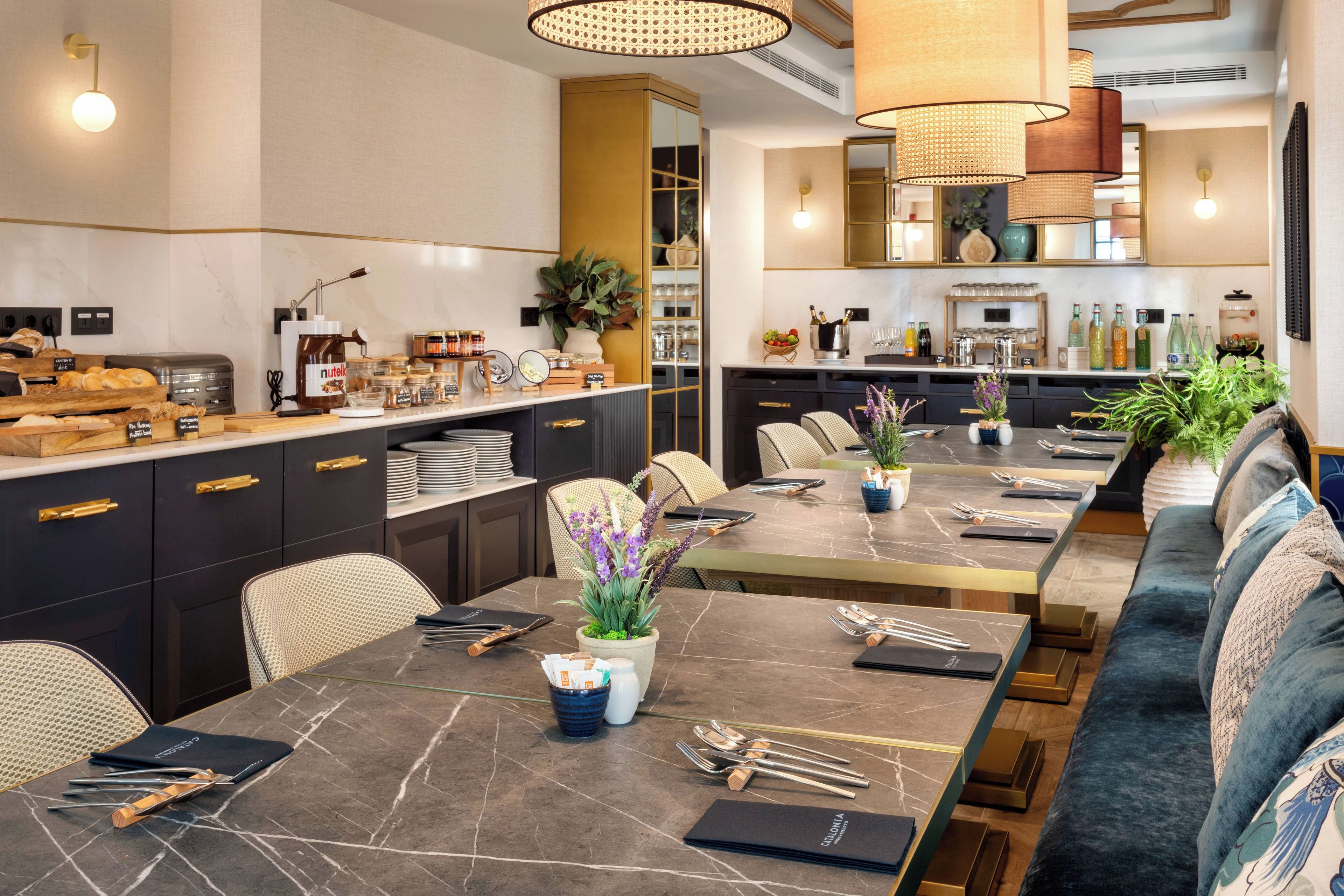 A modern dining area with a long table, chairs, and a sofa.
