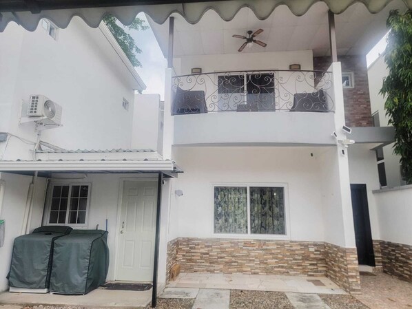 Une maison à deux étages dotée d’un patio couvert, d’un ventilateur de plafond et d’une caméra de surveillance.