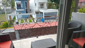 A balcony with wicker furniture and a metal railing.