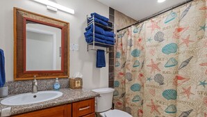 A bathroom with two sinks, a mirror, a towel rack, and a shower curtain with a beach theme. - Secluded Forest Retreat Full Kitchen, AC, W/D (Kailua)