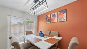 Un comedor con una mesa, sillas y una obra de arte en la pared.