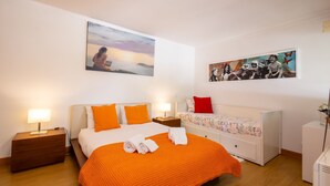 Et hotelværelse med en stor seng, to sengeborde, et natbord, en kommode og en radiator.