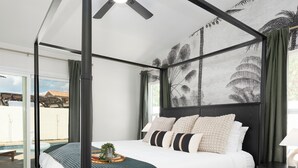 A four-poster canopy bed with a ceiling fan, a view of the outdoors through a sliding door, and a checkered rug on the floor. - NEW! Serene Designer 3BR near Polo & Tennis- SaltPool+Spa, GameRm, Firepit, Golf (Indio)