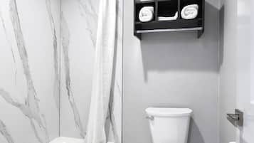 Un baño con bañera, inodoro y toallero.