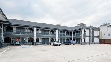 A multi-story building with a central courtyard, parking spaces, and a blue handicap-accessible sign.
