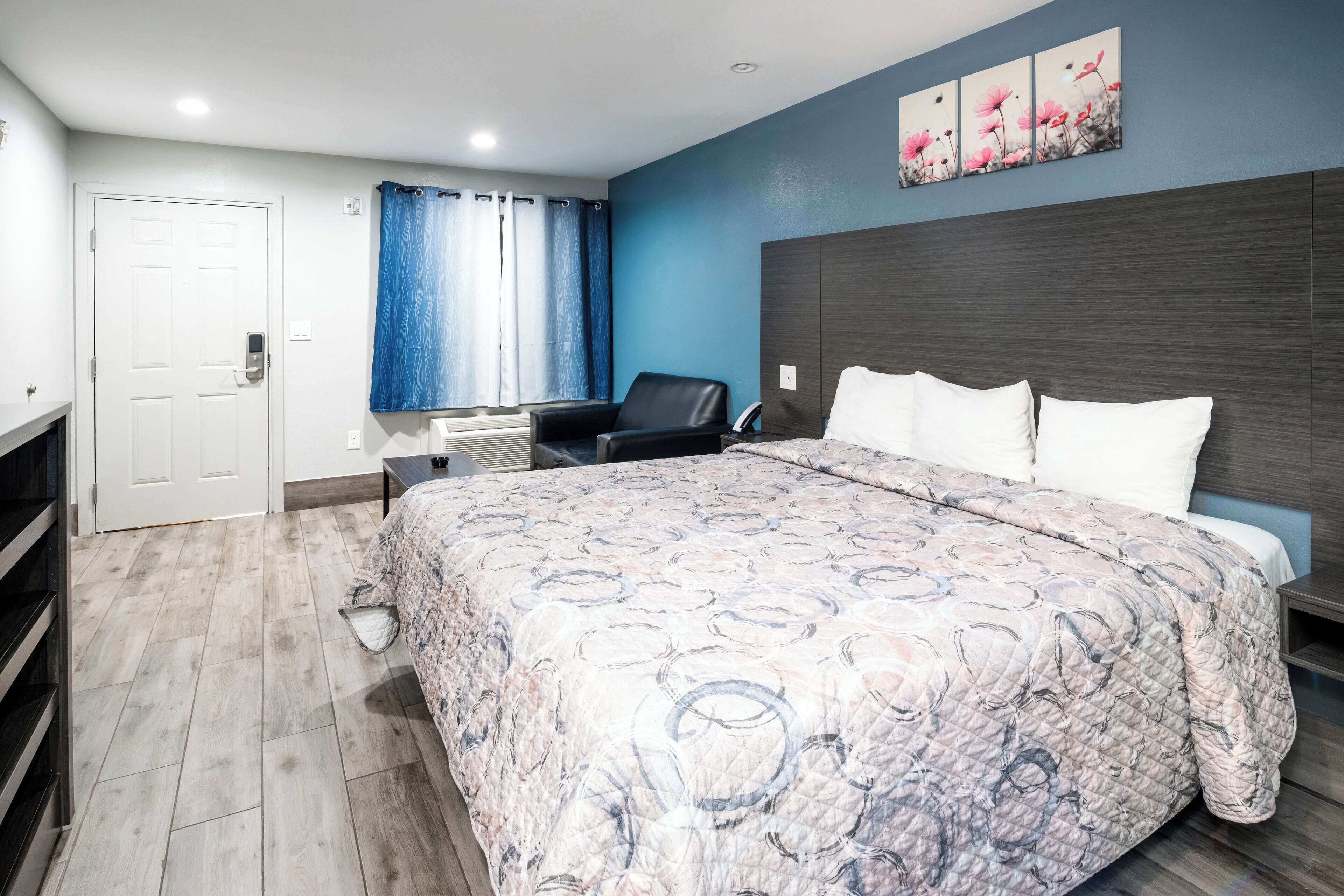 Un dormitorio con una cama grande, un escritorio, una silla y un rincón de ducha.
