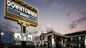 A hotel sign with "DOWNTOWN INNS" and a welcoming message.