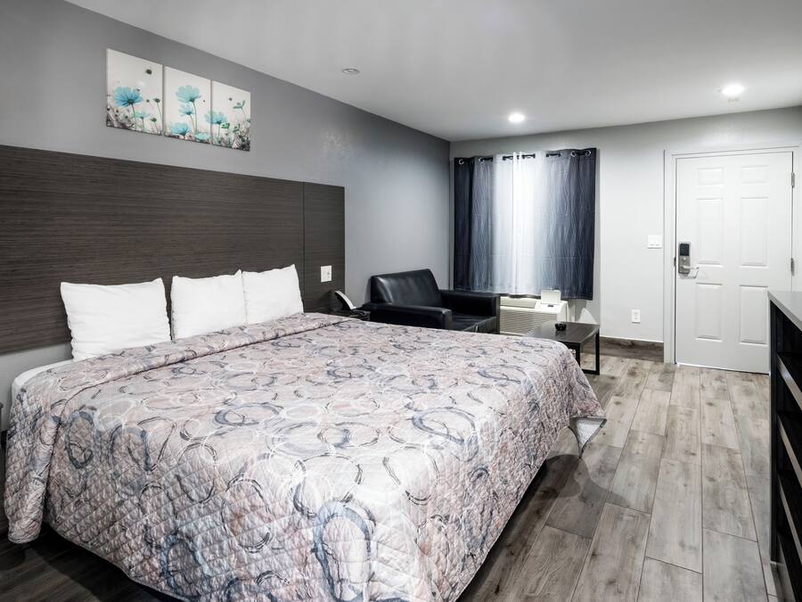 Une chambre d’hôtel moderne équipée d’un grand lit, d’un bureau, d’une chaise et d’une armoire.