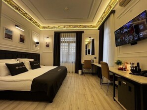 A hotel room with a bed, desk, chair, TV, and a mirror. - Sultanahmet Hotel Angel S Home (Istanbul)