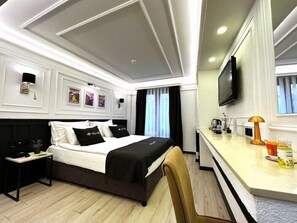 A hotel room with a bed, bedside tables, a desk with a lamp, a TV, and a window with curtains. - Sultanahmet Hotel Angel S Home (Istanbul)