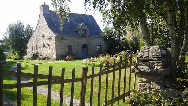 A stone building with a blue door, surrounded by a wooden fence and a stone path leading to it. - Fisherman's cottage Seasonal rental July (Piriac-sur-Mer)