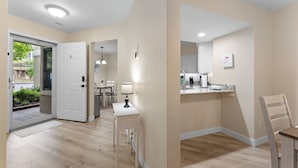 A modern apartment with a kitchen, dining area, and a door leading to a balcony. - Updated 2 bedroom walk-in with 2 king beds in Pointe Royale Golf Village (Branson)