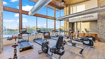 Une salle de sport équipée de tapis de course, de vélos d’appartement et d’appareils de musculation.