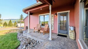 Una casa con porche cubierto, un letrero de bienvenida y vistas al paisaje.