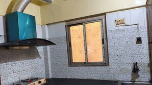 A kitchen with a gas stove, a window with a view, and a sink.