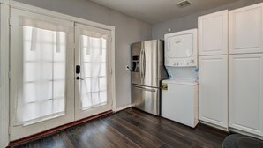 A kitchen with a refrigerator, microwave, and oven.