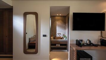 A modern bathroom with a large mirror, a sink, and a built-in shower.