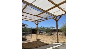 A covered outdoor area with a wooden frame and a white canopy. - Wild Goose Ranch (Homestead Valley)