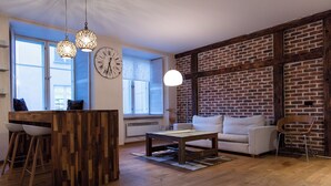 Una sala de estar moderna con una mesa de centro de madera, un sofá y un comedor con taburetes.