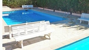 A swimming pool with a white bench and a metal ladder. - Quiet village center and seaside T2 apartment with swimming pool and private parking. (Fréjus)