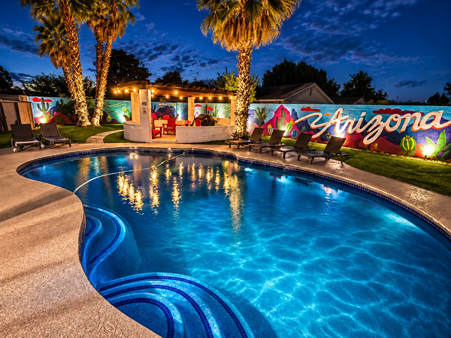 A swimming pool with lounge chairs and a bar area, surrounded by palm trees and a mural with the word 'Arizona'.