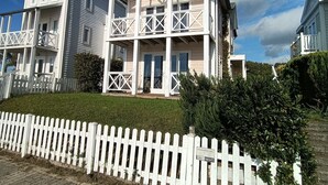 A multi-story building with balconies, a white picket fence, and a clear sky. - 1st line water front 5 Minutes to the beach and 10 mins to old town center. (Hellevoetsluis)